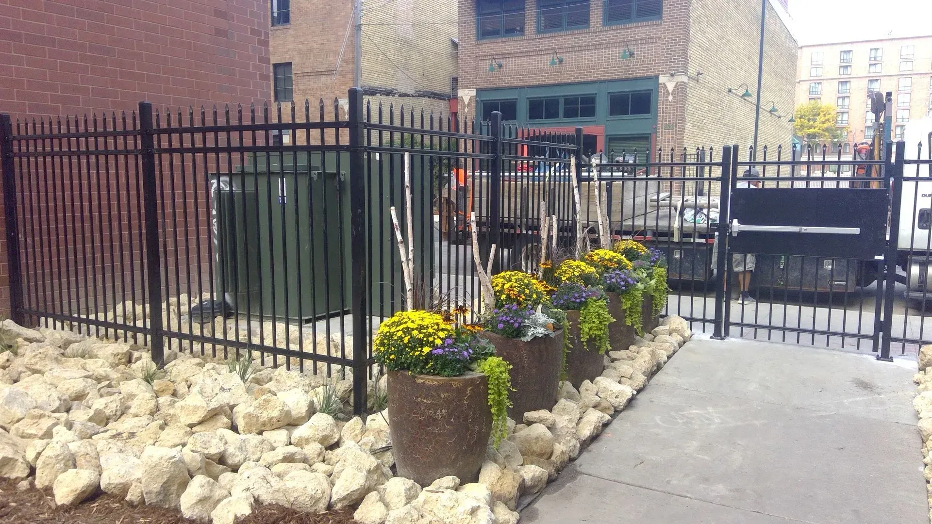 A fence with a row of potted plants in front of it