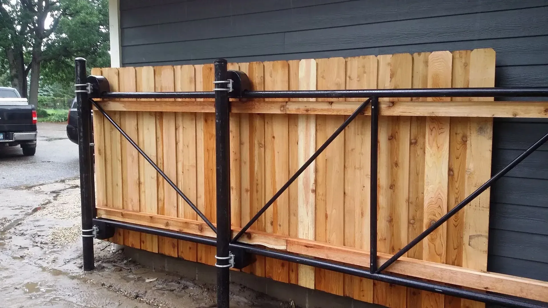 A wooden fence is being built on the side of a house