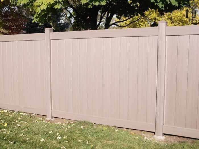 A wooden fence is sitting in the middle of a lush green field.
