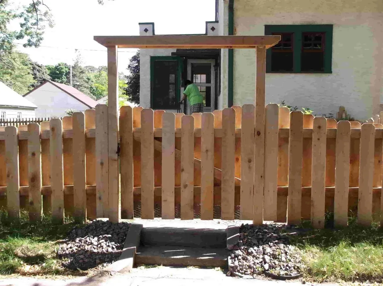 A wooden fence with a gate in front of a house