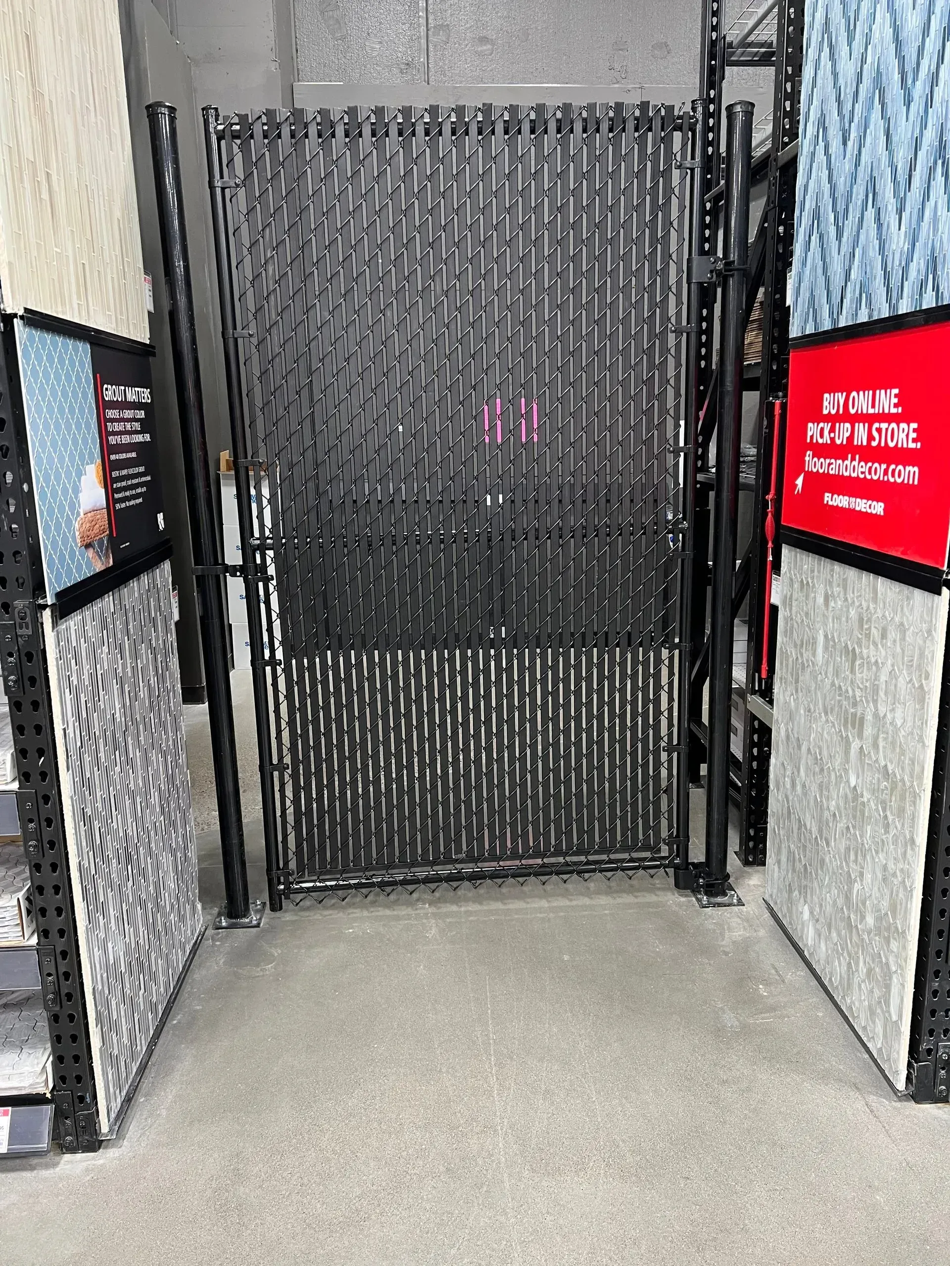 A display of carpets in a store with a fence in the middle of the room.