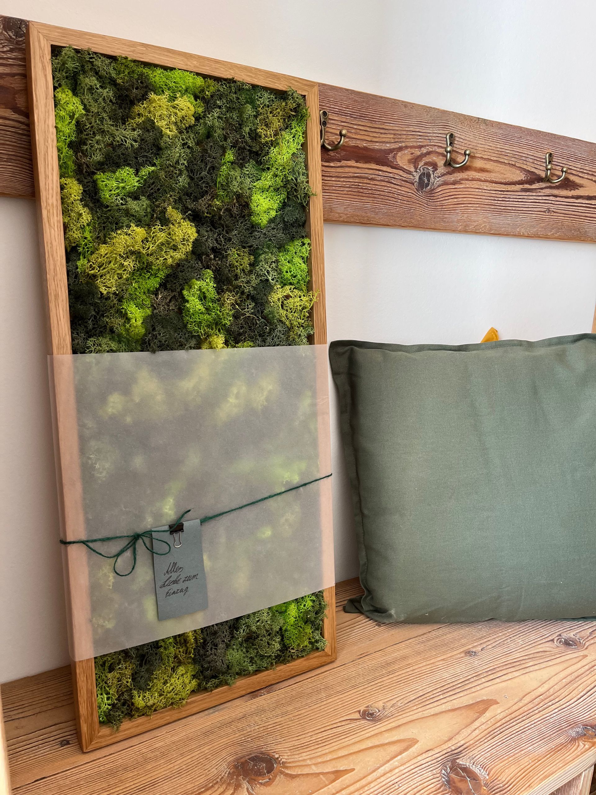 Moosbild aus echtem Moos mit Eiche-Rahmen vor Garderobenleiste aus Altholz Kiefer mit Garderobenhaken.