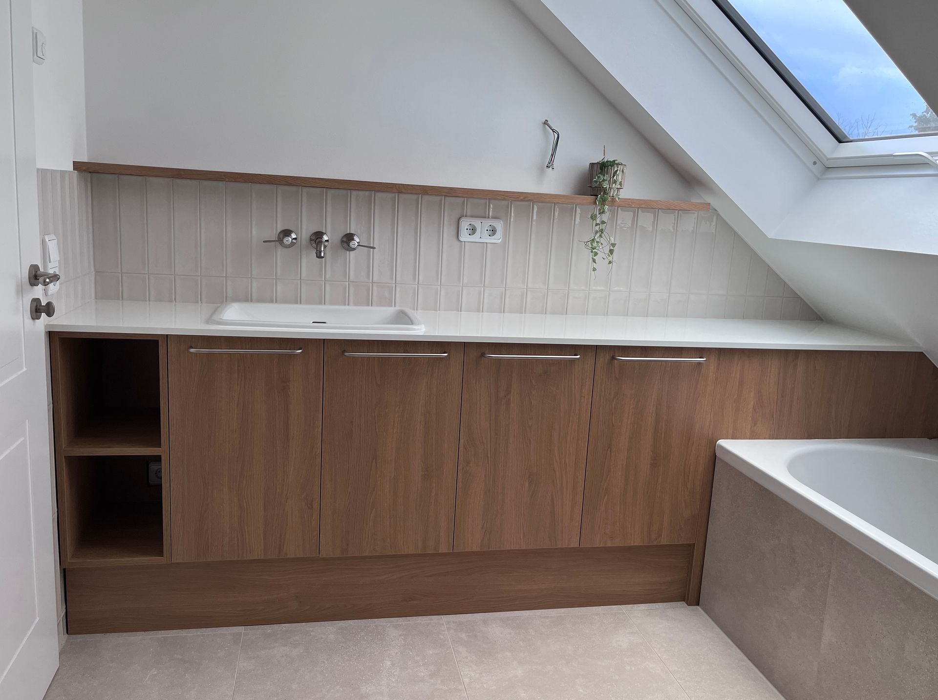 Badmöbel. Waschbecken-Unterschrank in Eiche-Optik mit Stauraum und Türen und einem offenen Regalfach.