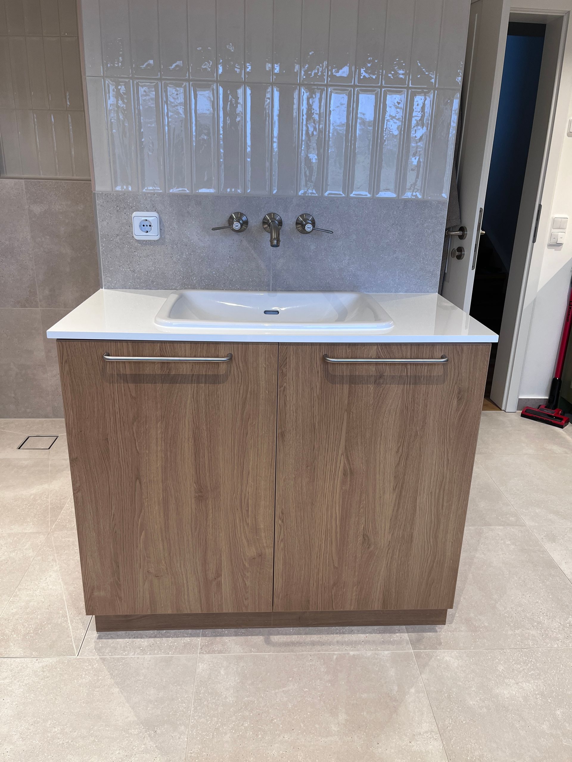 Badmöbel. Waschbeckenunterschrank in Eiche-Optik mit Drehtüren. Deckplatte in Hochglanz weiß.