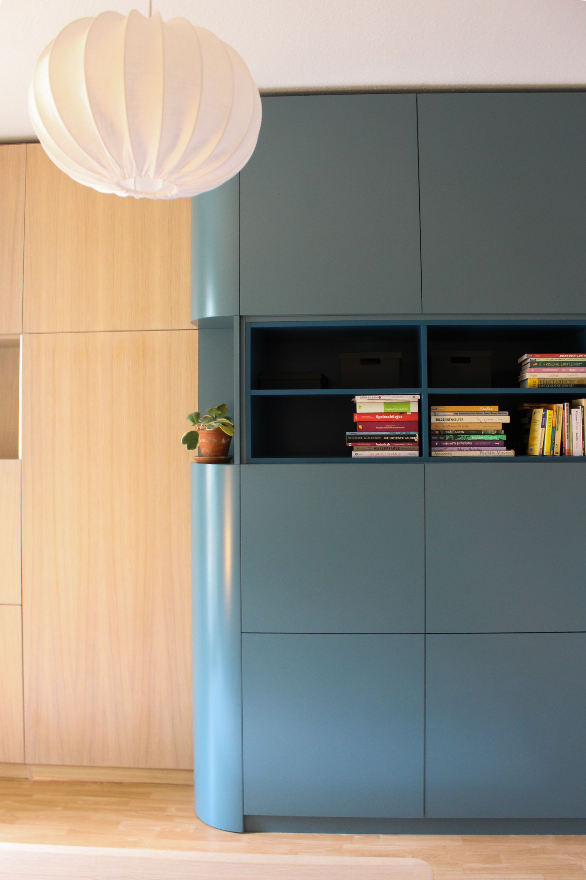 Raumtrenner raumhoch in Eiche und petrolfarbenen Oberflächen.