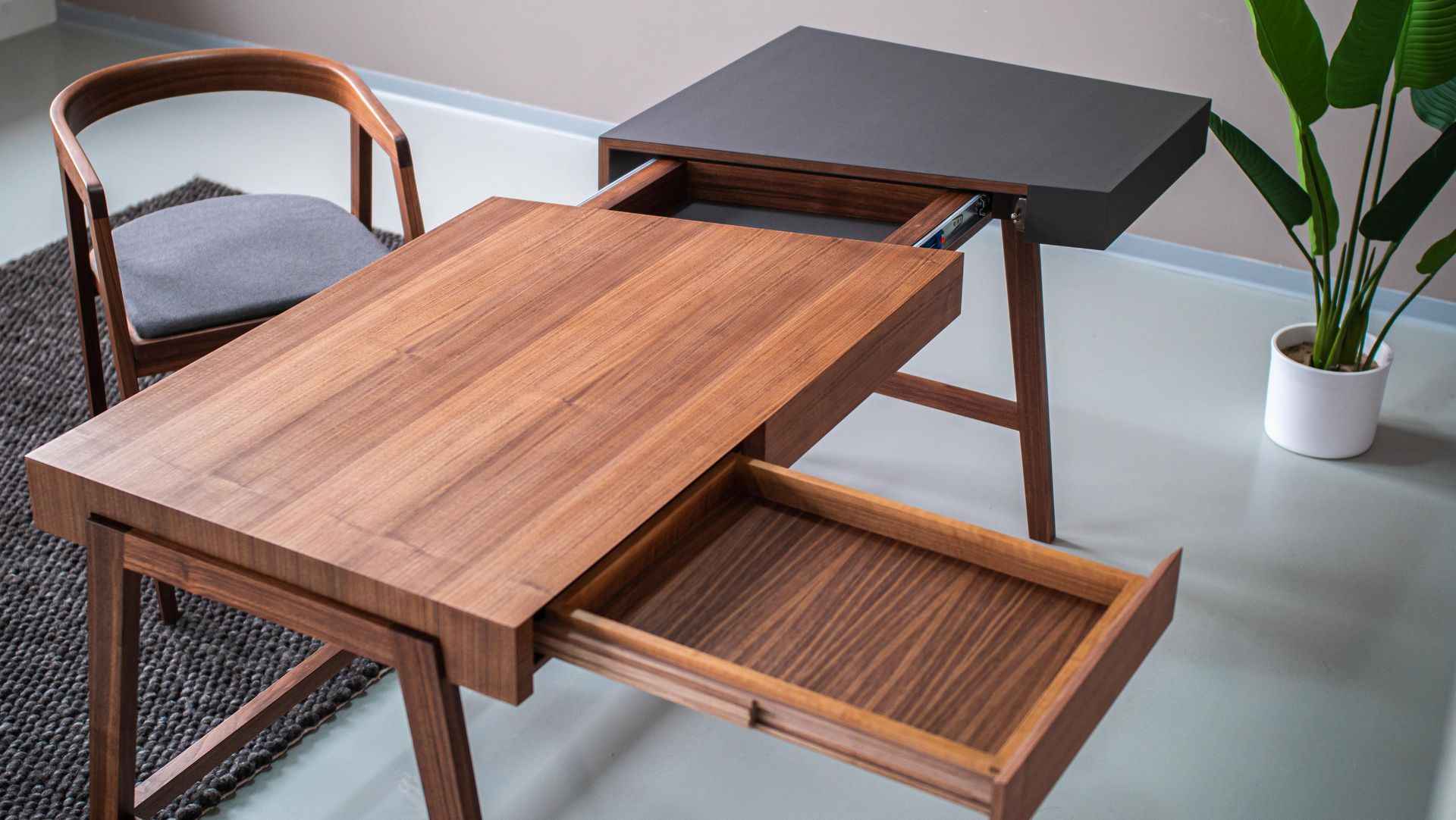 Stuhl und Schreibtisch in geöltem Nussbaum mit Massivholz-Kulissenauszug und seitlich geöffneter Schreibtischplatte.