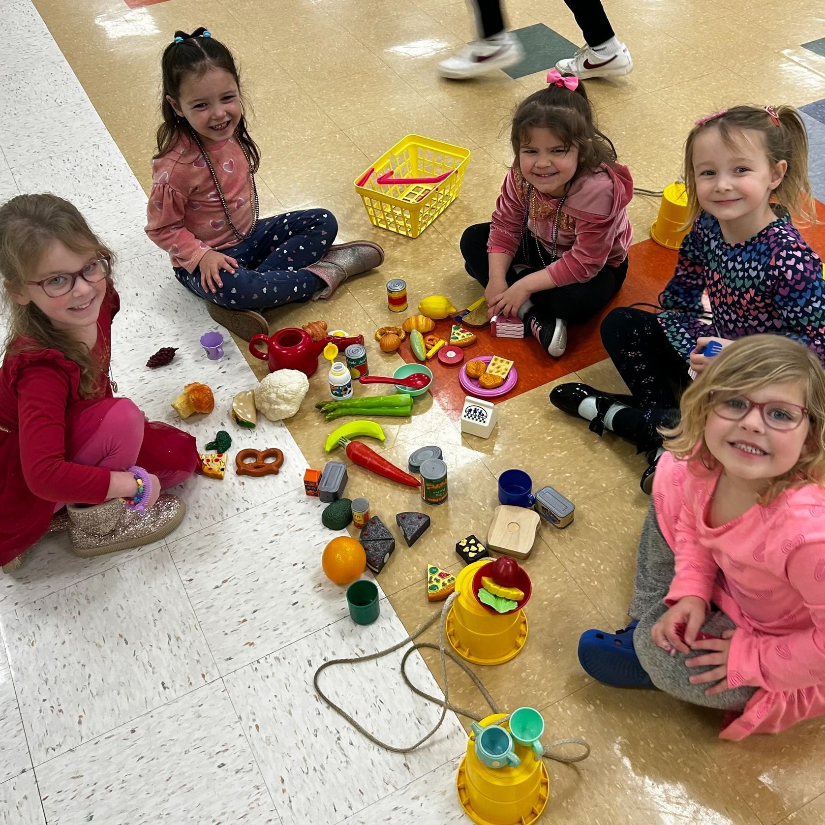 A group of children are playing with foam blocks on a wooden floor