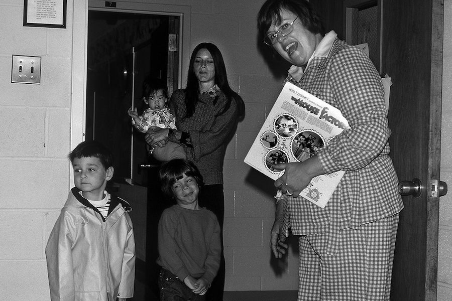 A black and white photo of a woman holding a wood book