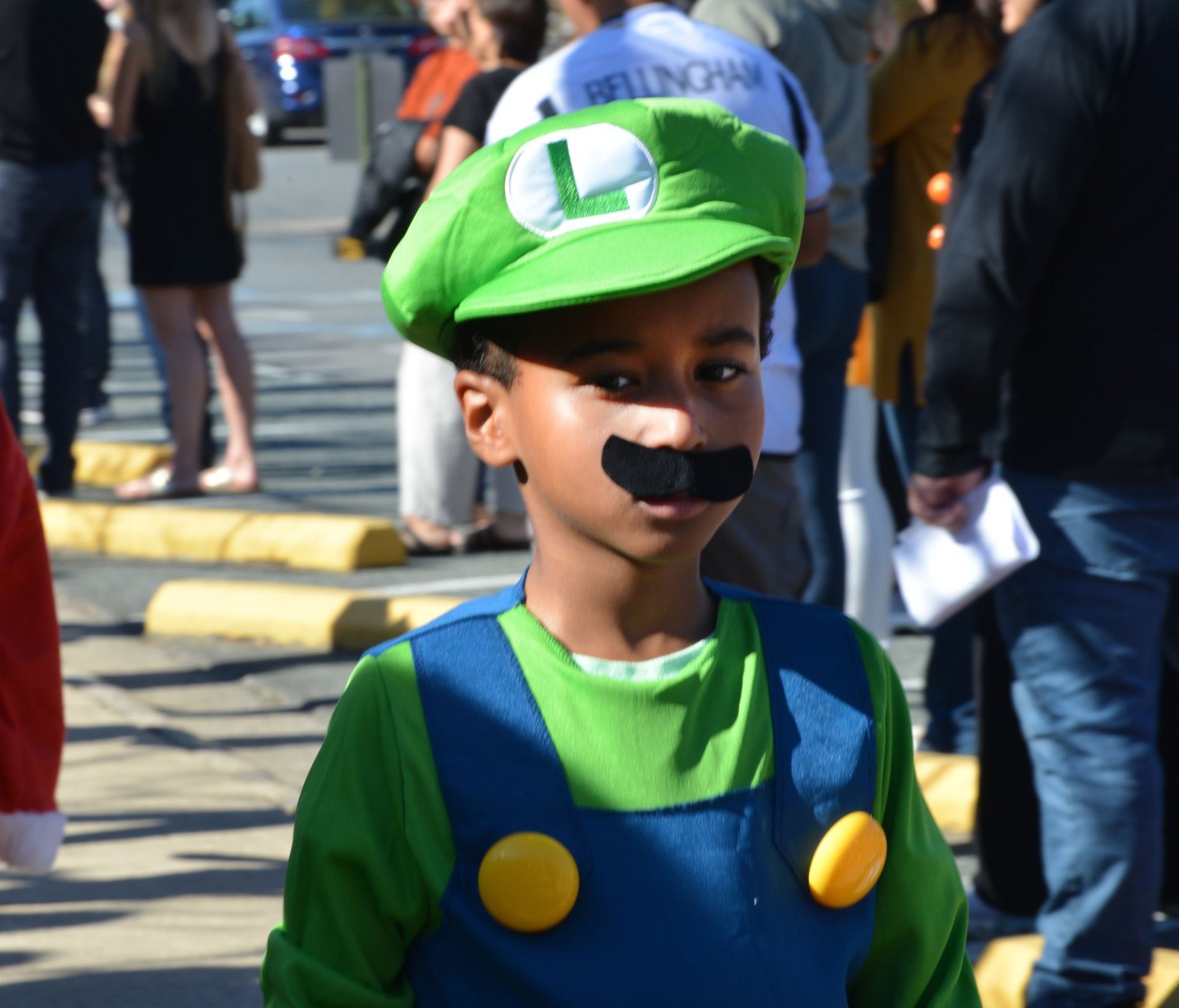 A young boy wearing a baseball uniform and an eagle hat