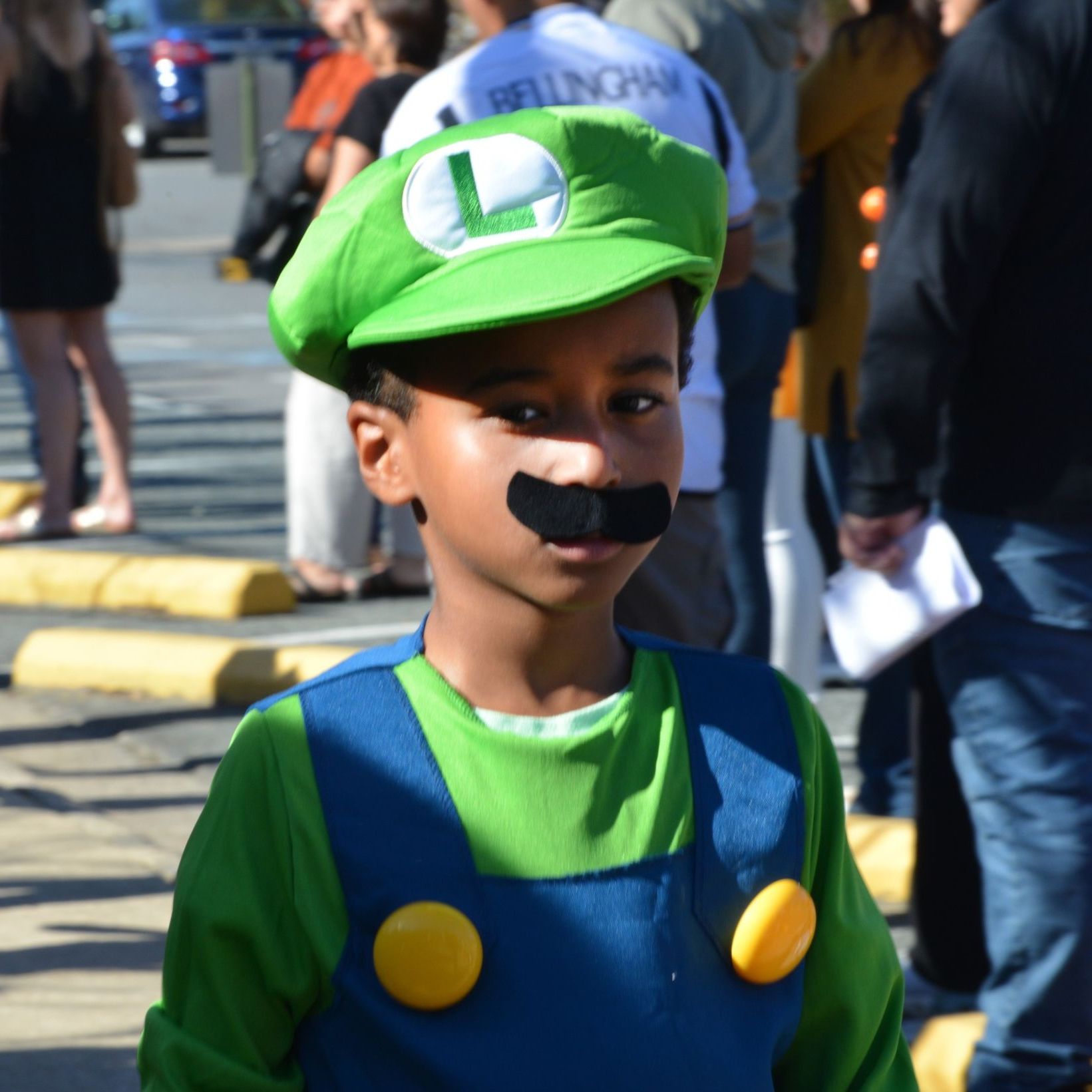 A young boy wearing a baseball uniform and an eagle hat