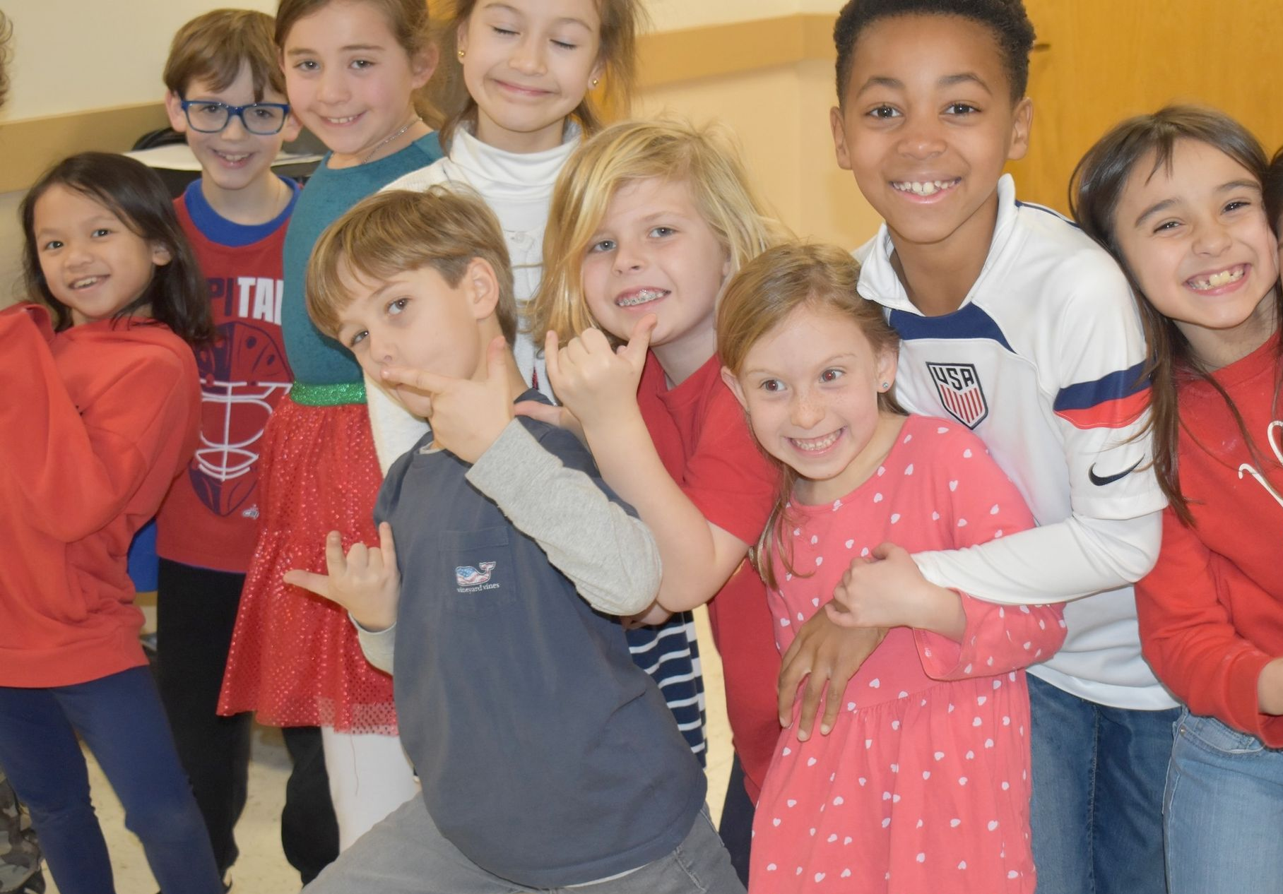 A group of children wearing shirts that say sbs are posing for a picture