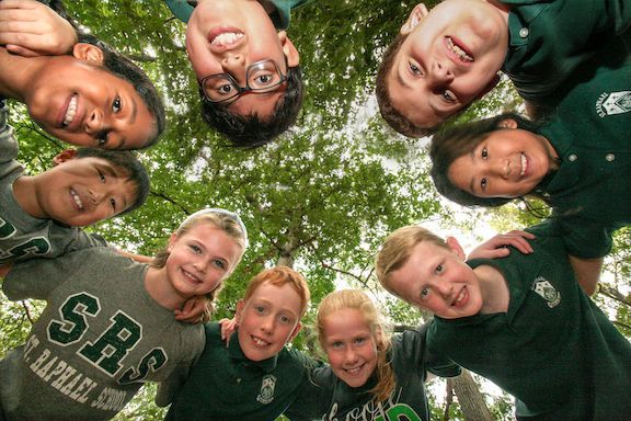 A group of children wearing shirts that say sbs are posing for a picture