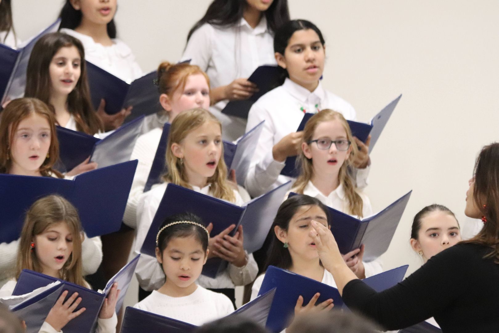 A group of young girls are singing in a choir