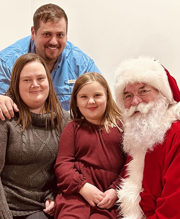 A family is posing for a picture with santa claus.
