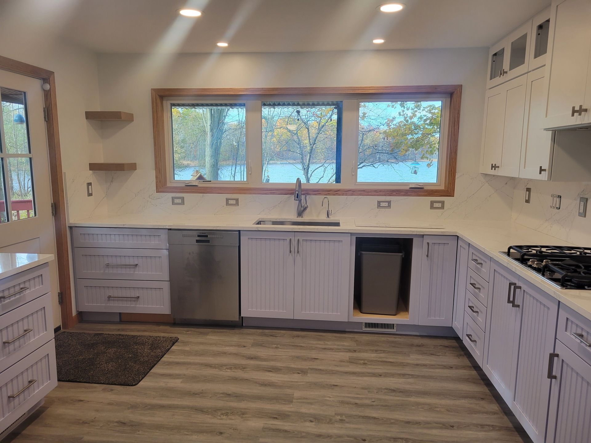 Kitchen with white cabinets, stainless steel appliances, and a window overlooking a body of water.