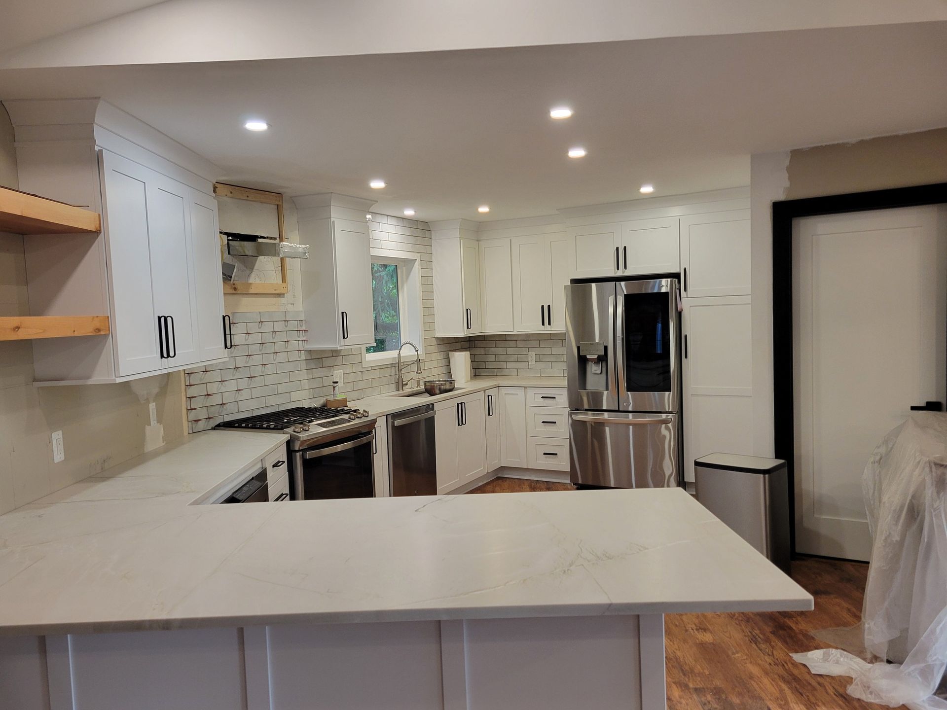 Newly renovated kitchen with white cabinets, stainless steel appliances, and quartz countertops.