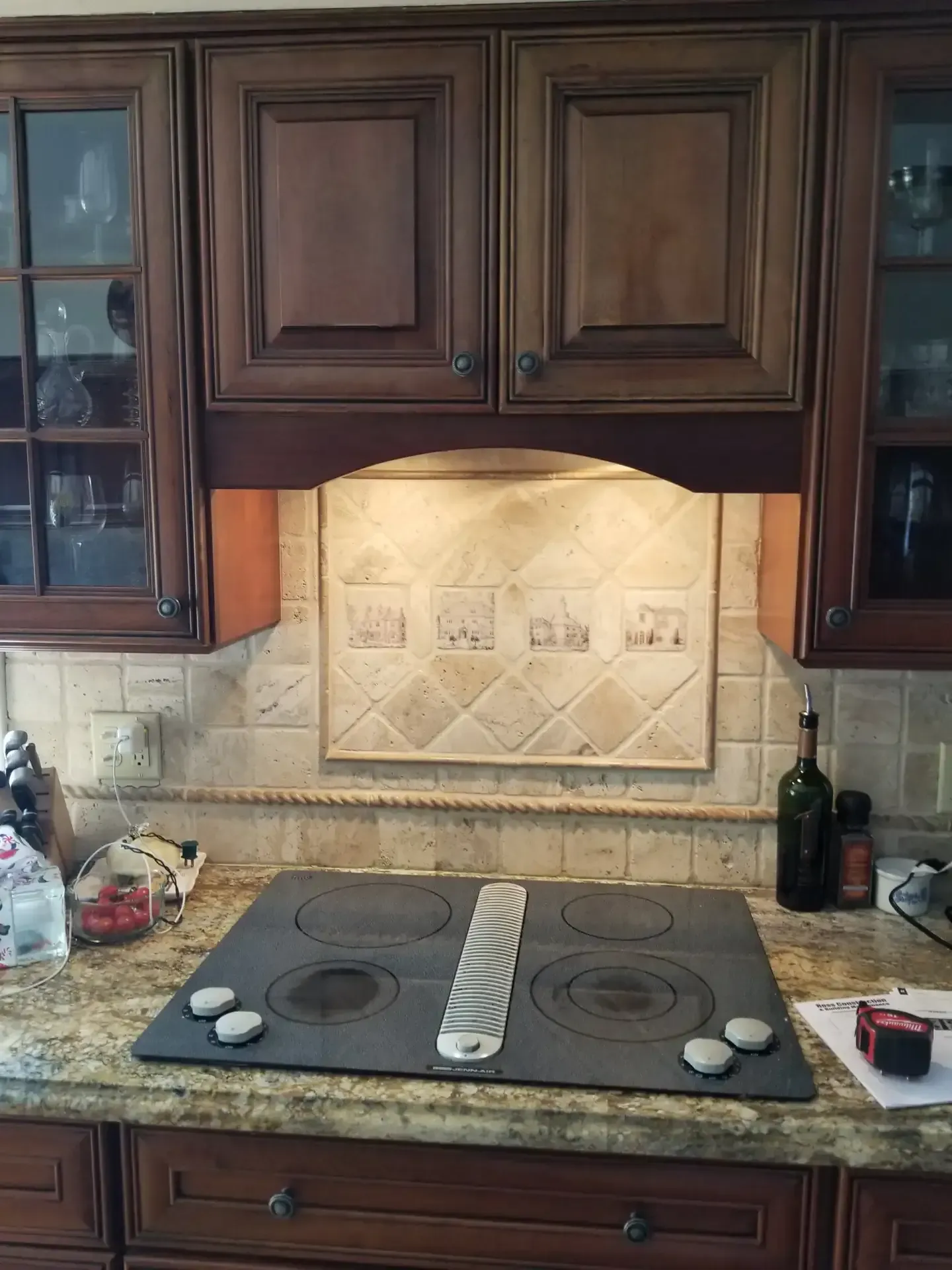 Kitchen stove and cabinets. Dark wood cabinets with stove and tiled backsplash.