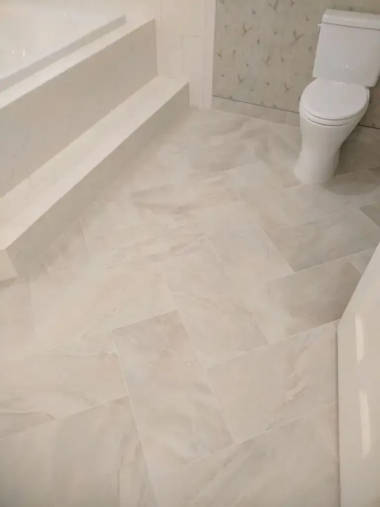 White bathroom floor with tile, steps, and toilet.