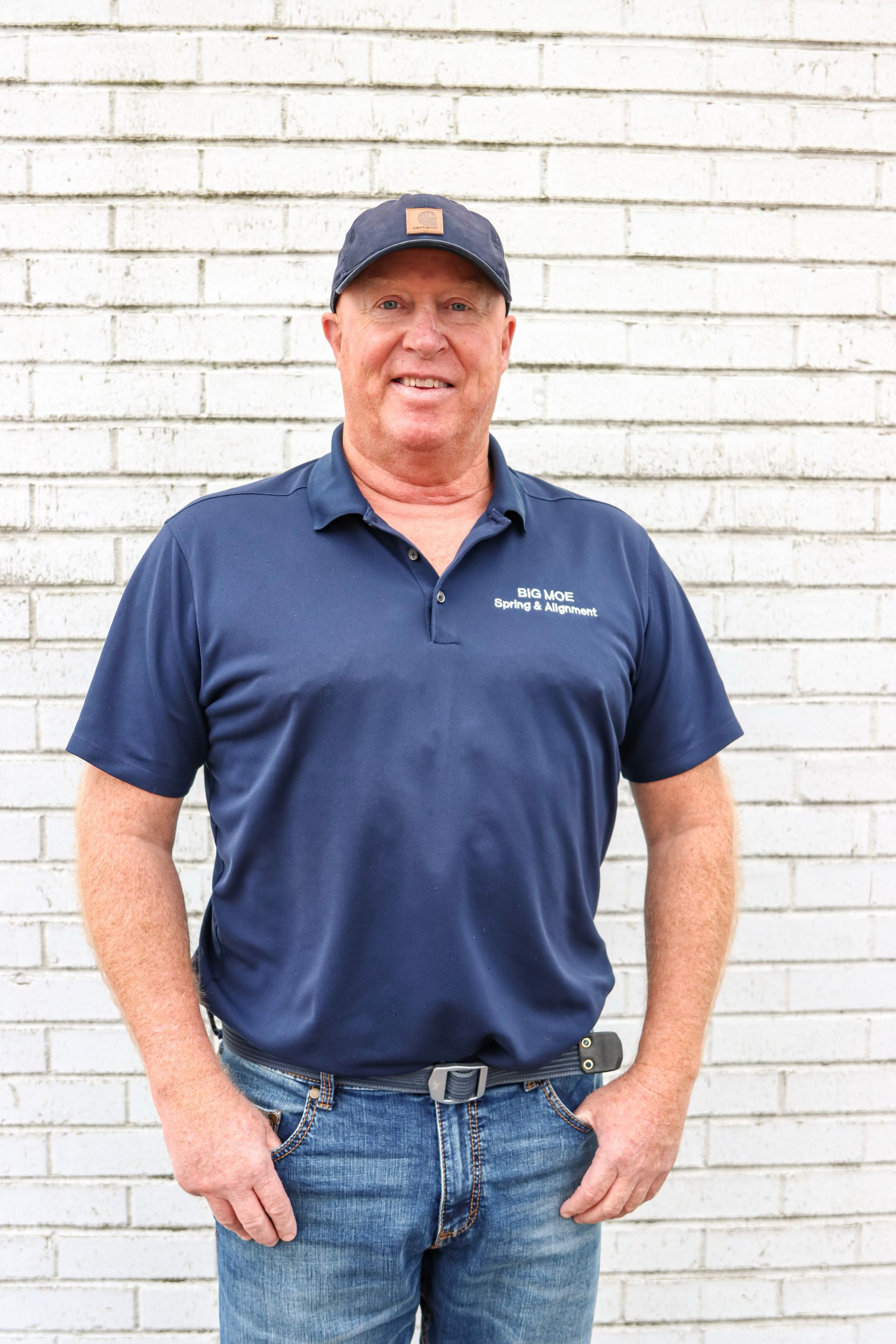 A Man With A Blue Cap Wearing A Polo Shirt – Fairfield, AL - Big Moe Spring & Alignment of B'Ham