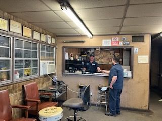 A man is standing in front of a counter in a garage – Fairfield, AL - Big Moe Spring & Alignment of B'Ham