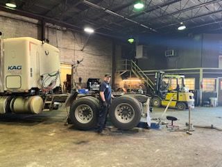 A man is working on a semi truck in a garage – Fairfield, AL - Big Moe Spring & Alignment of B'Ham