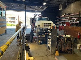 A man is working on a truck in a garage – Fairfield, AL - Big Moe Spring & Alignment of B'Ham