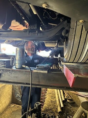 A man is working underneath a car on a lift – Fairfield, AL - Big Moe Spring & Alignment of B'Ham