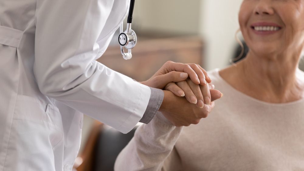 Doctor shaking hands with a smiling patient in a clinical setting