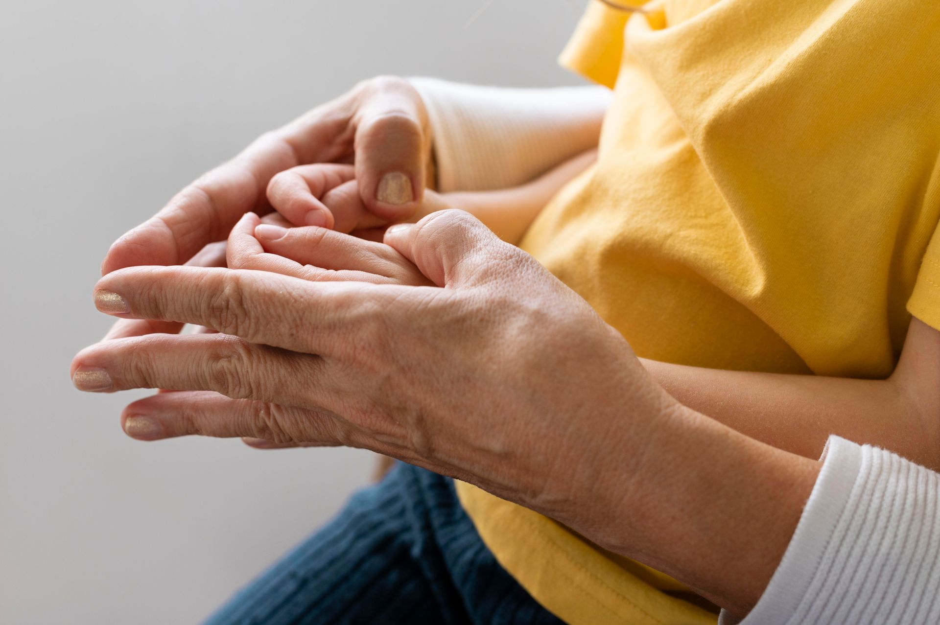 An elderly woman is holding a child 's hand.