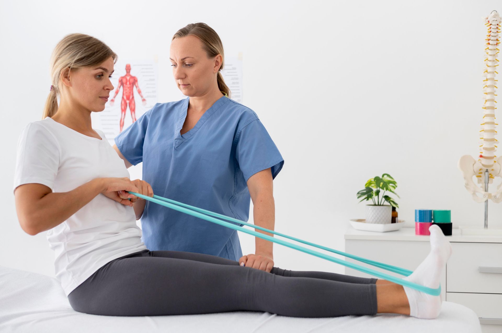 Woman in therapy exercises leg with band, guided by a healthcare professional.