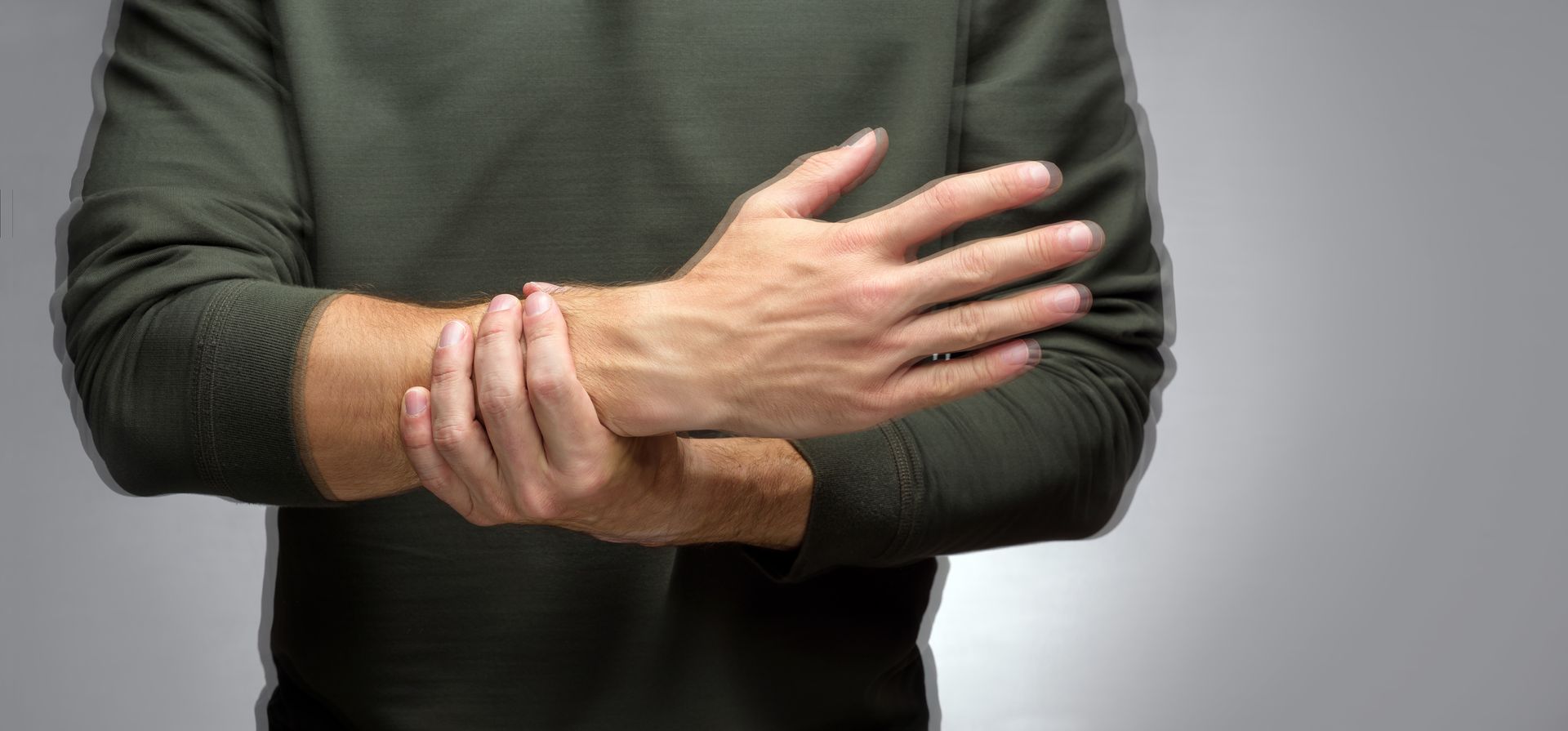 A man is holding his wrist in pain.