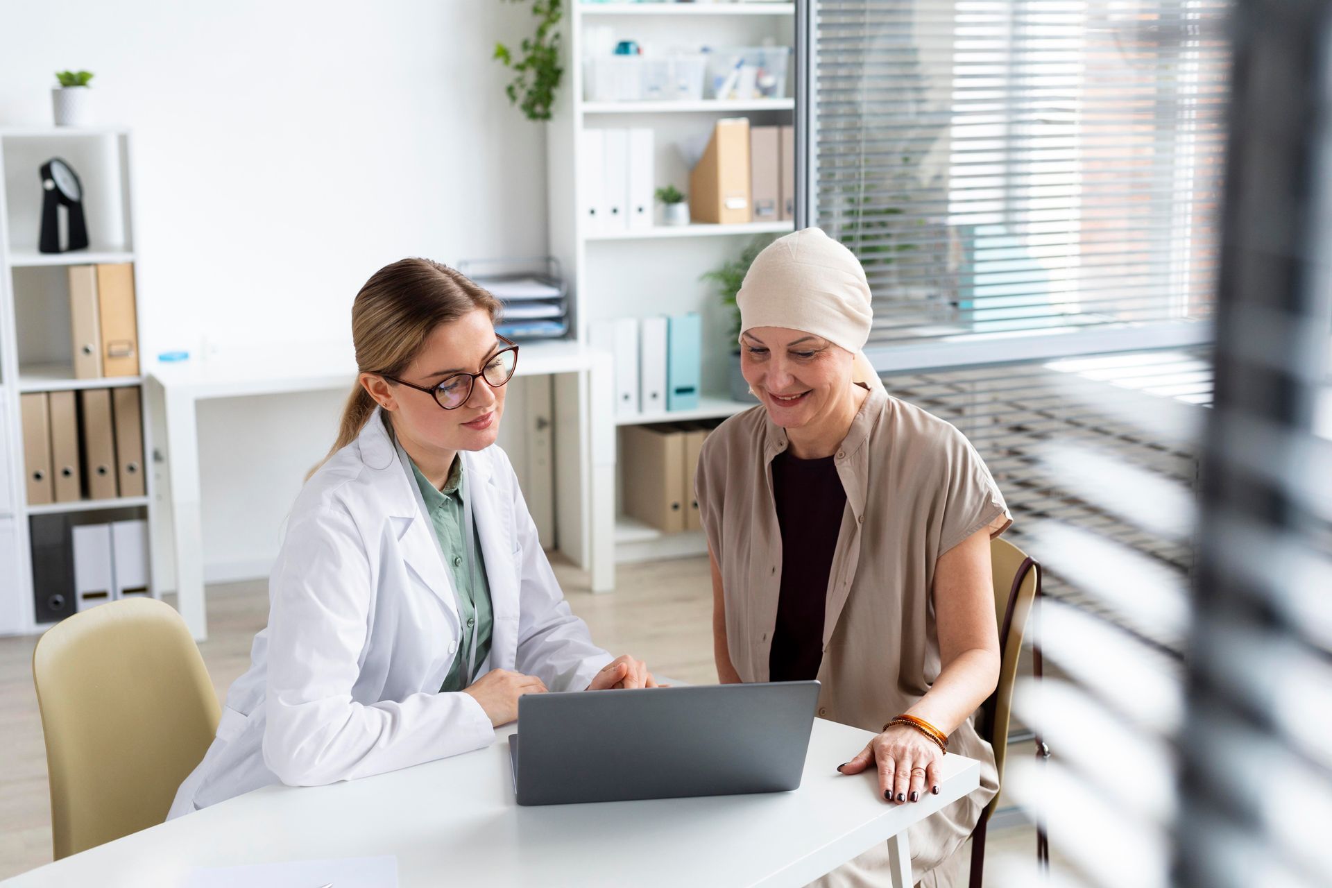 A doctor and a patient are looking at a laptop computer.