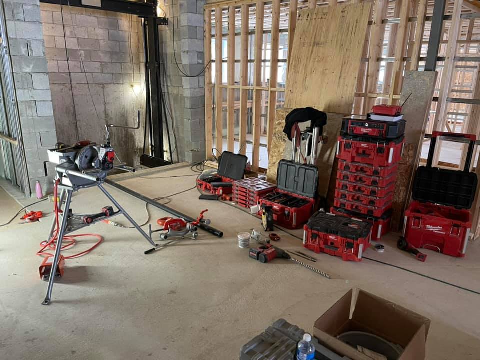 Un local en construction avec outils et coffres au sol.