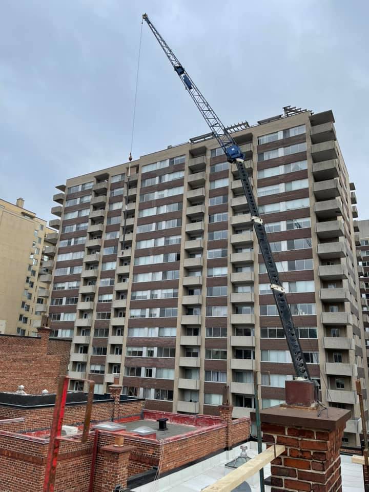 Un grand bâtiment en construction avec une grue devant lui.