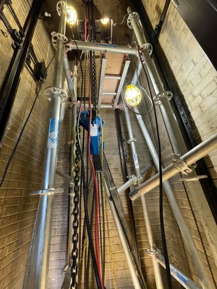 L'intérieur d'un ascenseur avec beaucoup de fils suspendus au plafond.