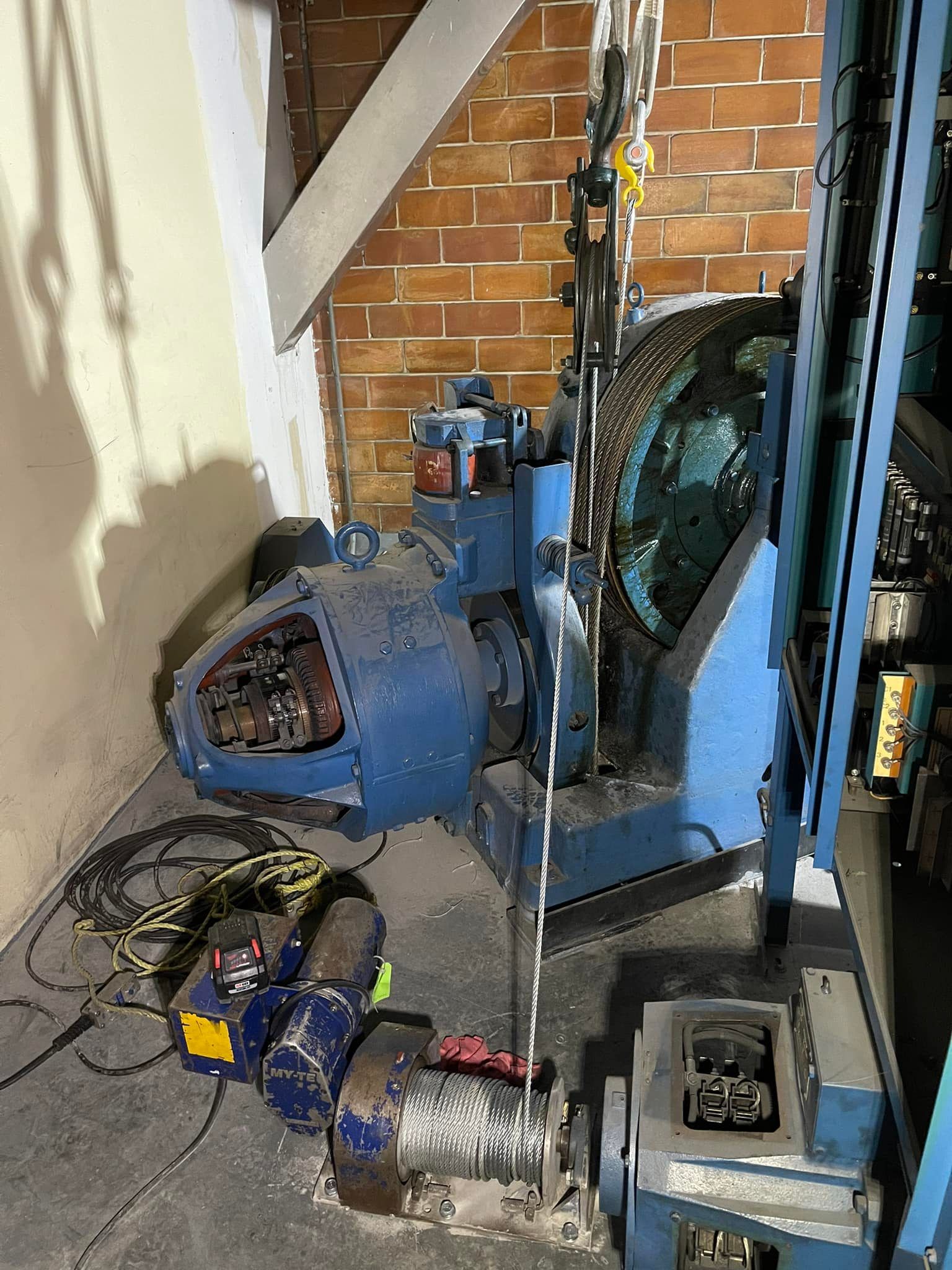 Une machine bleue est assise dans une pièce à côté d'un mur de briques.