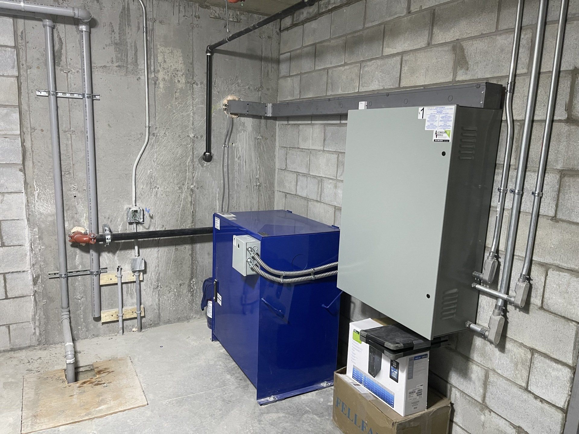 Une pièce avec une boîte bleue et une boîte blanche au sol.