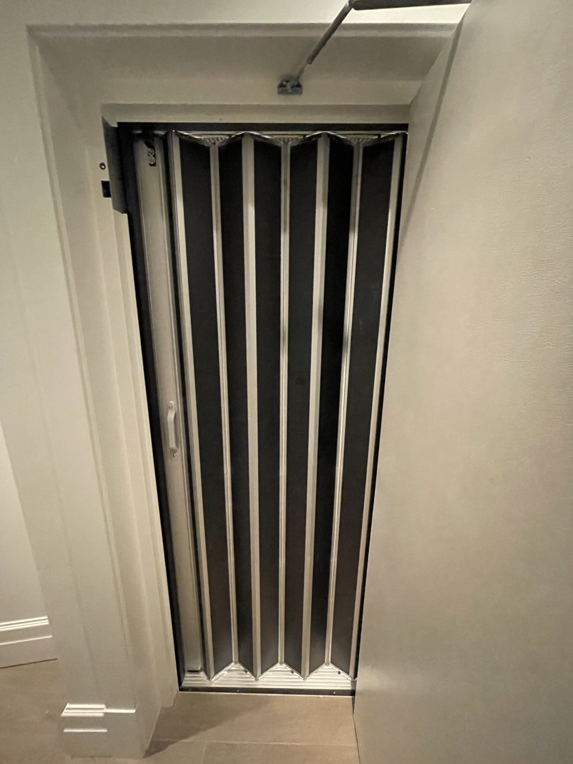 Une porte avec un rideau rayé noir et blanc dessus.