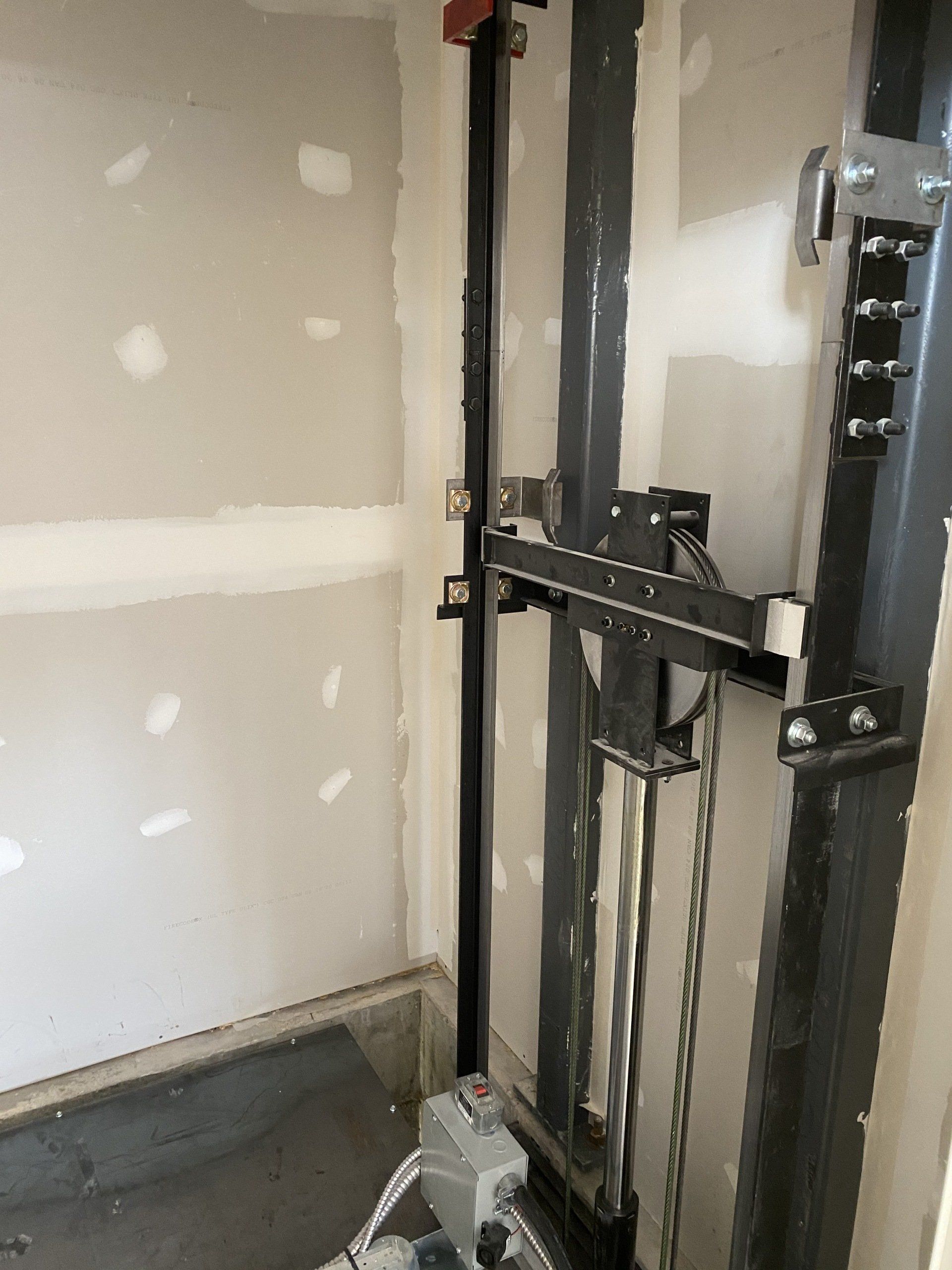 Un très vieil ascenseur est en construction dans une pièce.