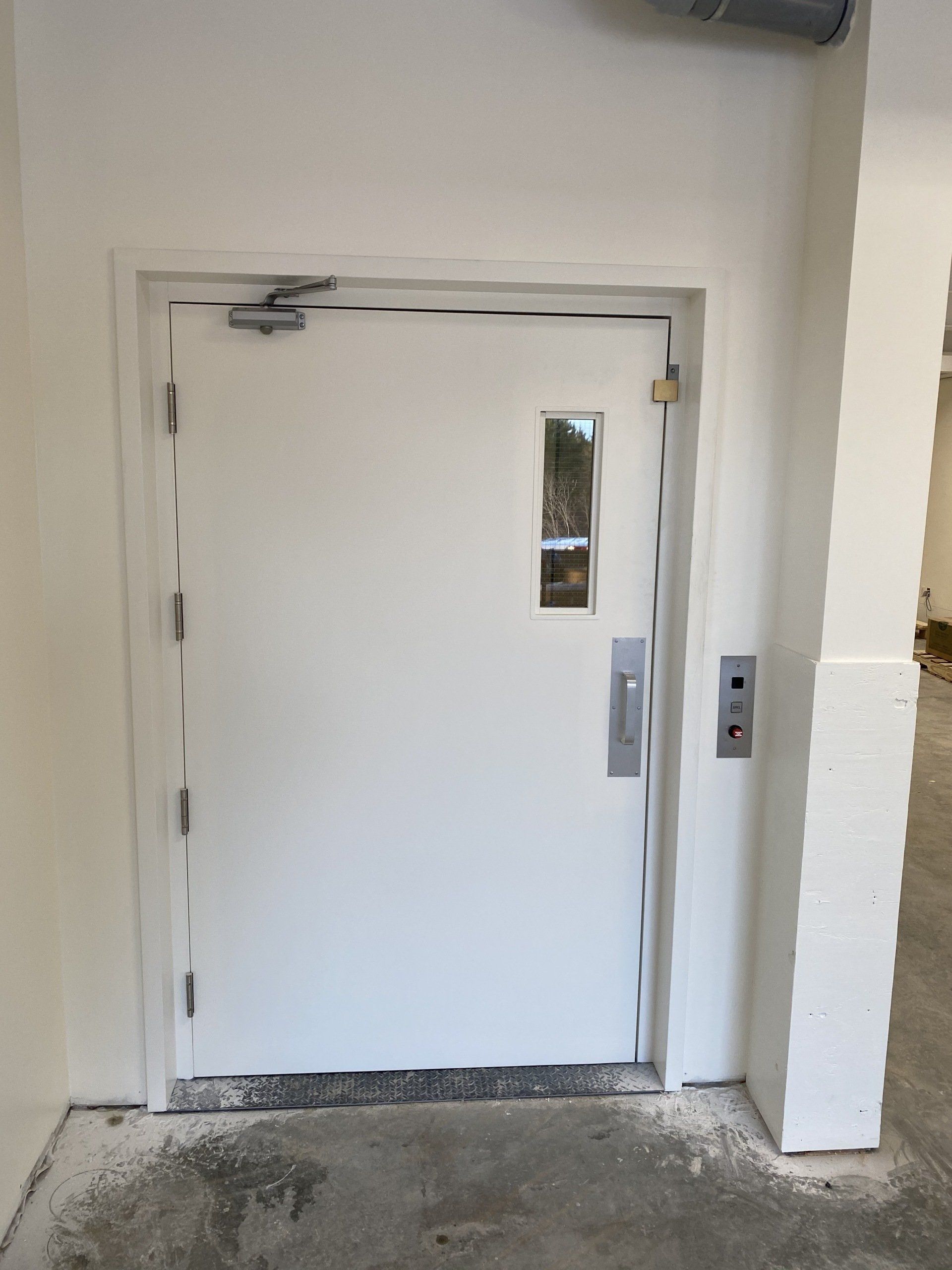 Une porte blanche avec une fenêtre dans un bâtiment.