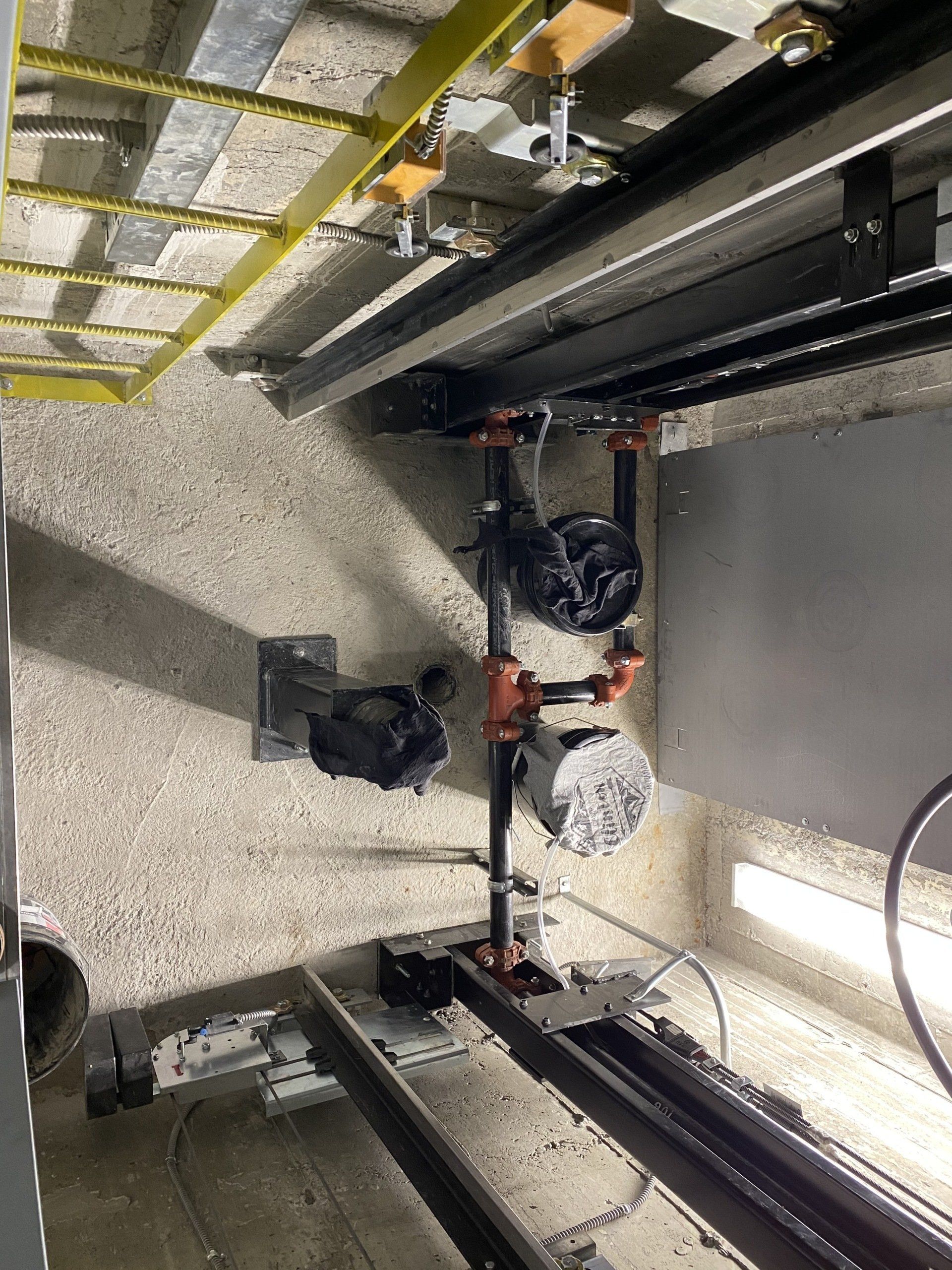 Une pièce avec beaucoup de tuyaux suspendus au plafond.