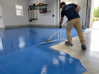 blue expoxy getting installed on a garage floor