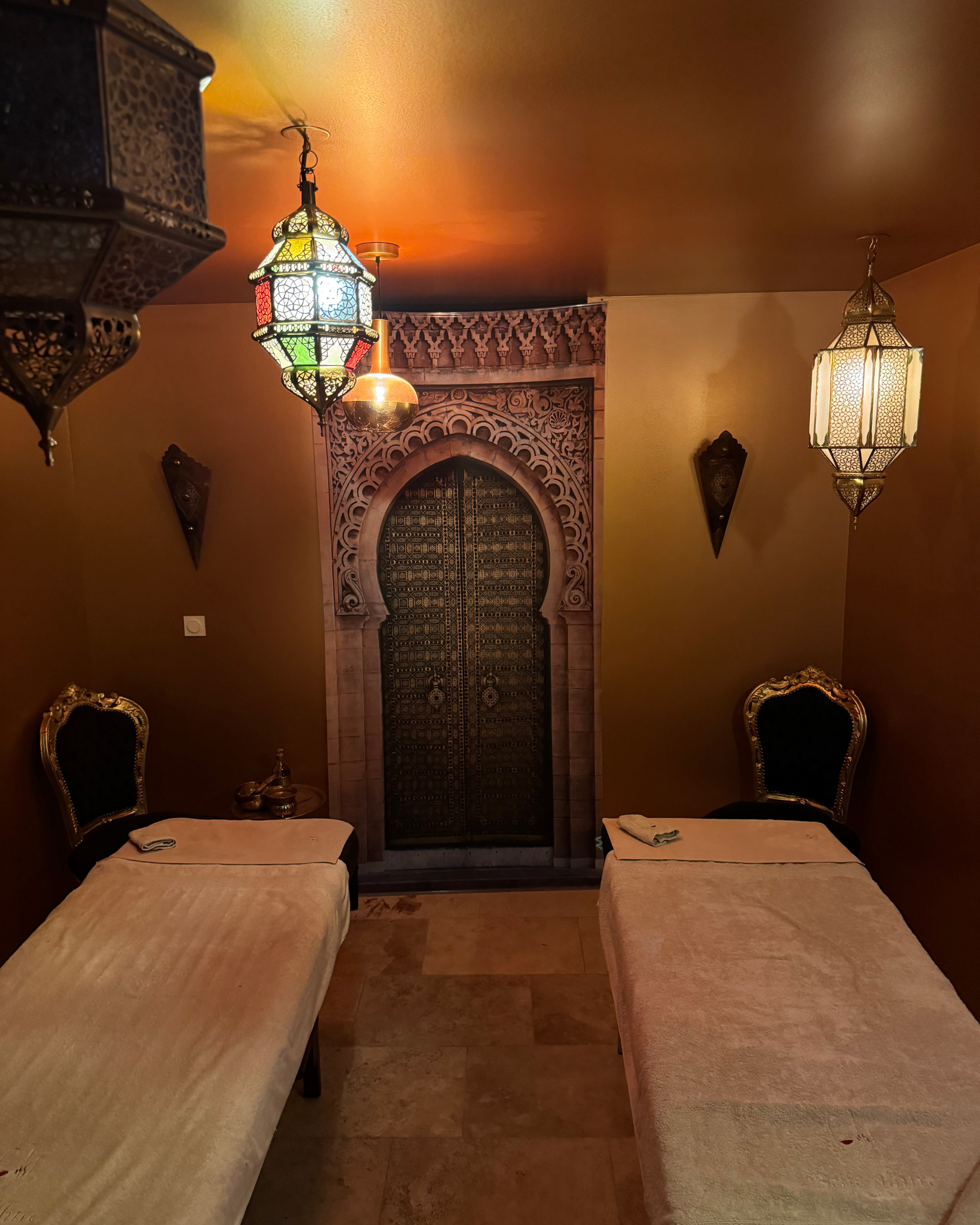 Salon de massage avec deux lits et une lanterne suspendue au plafond