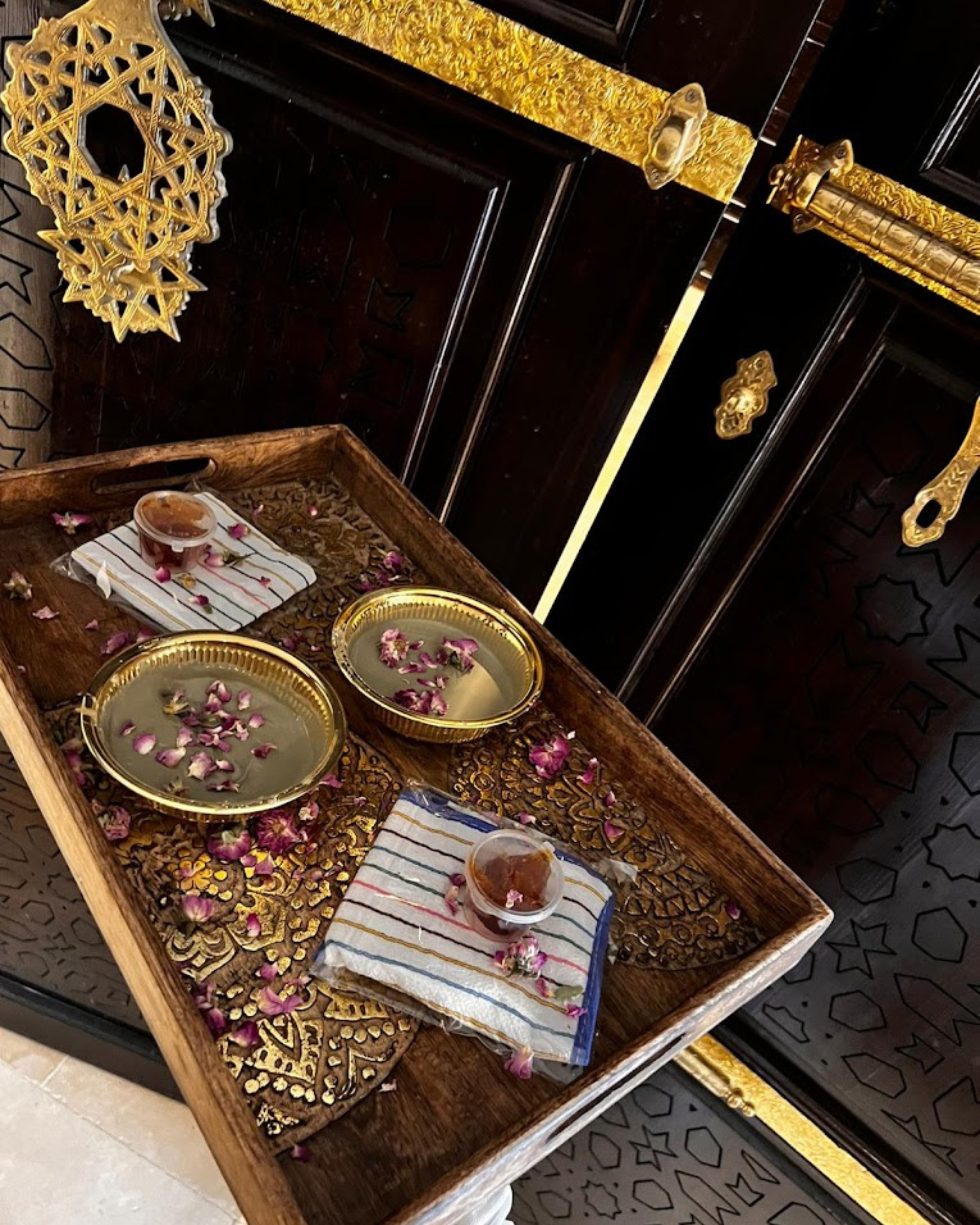 Un plateau en bois avec des bols de nourriture et des fleurs dessus