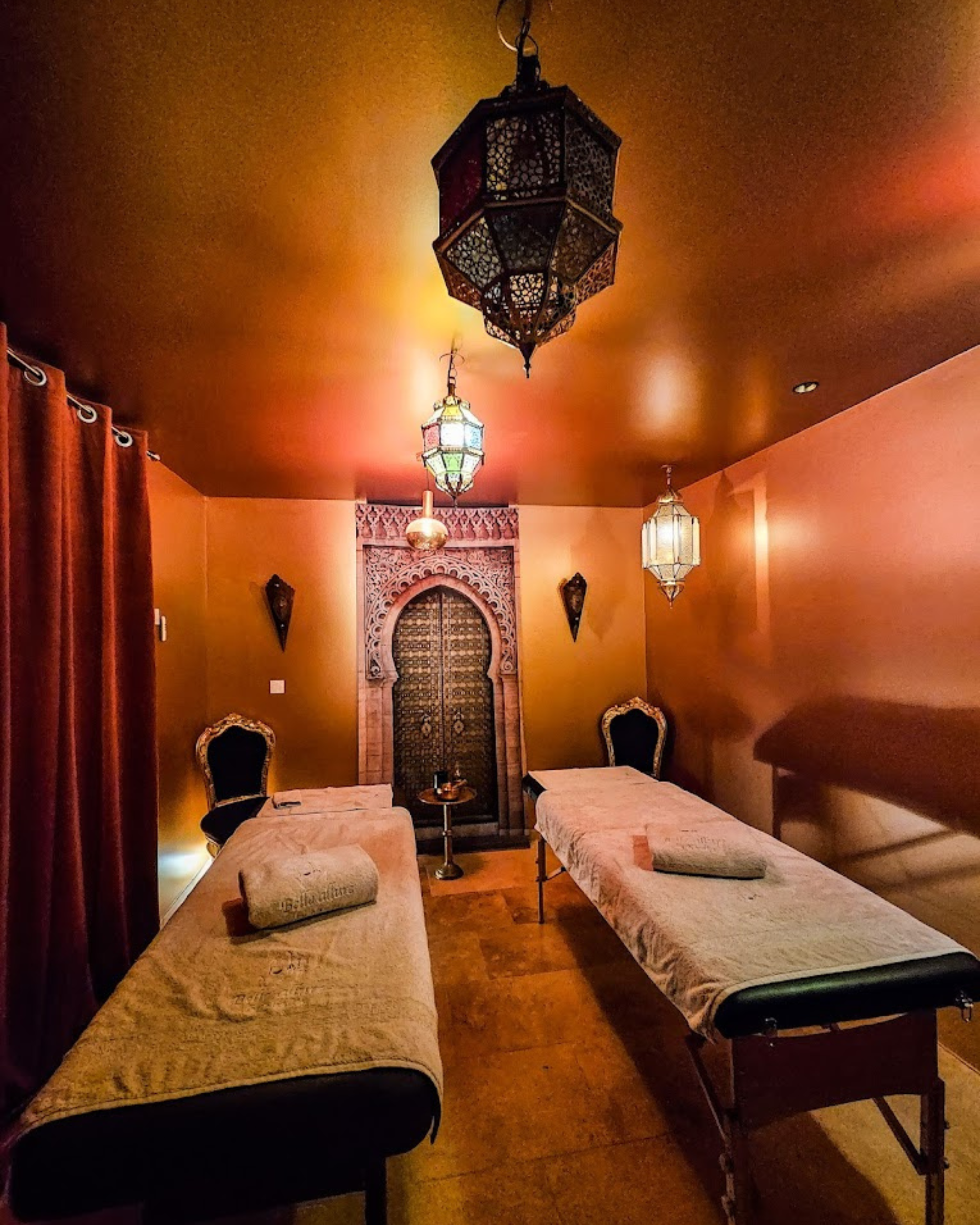 Salon de massage avec deux lits de massage et une lanterne suspendue au plafond