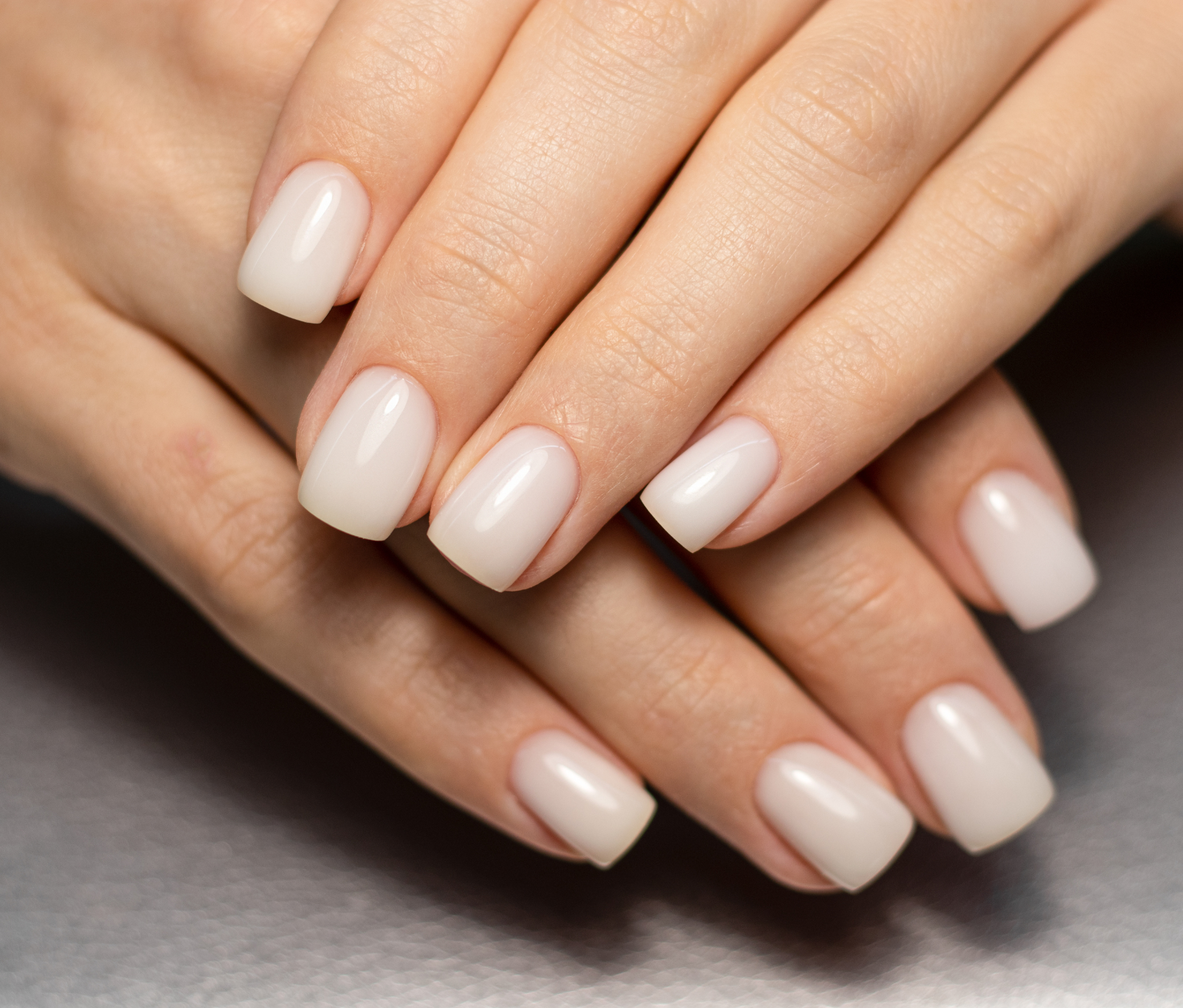 Des mains d'une femme avec des ongles blancs