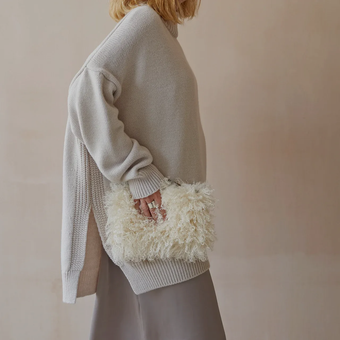 A close up of a woman wearing a necklace with a crescent moon pendant.