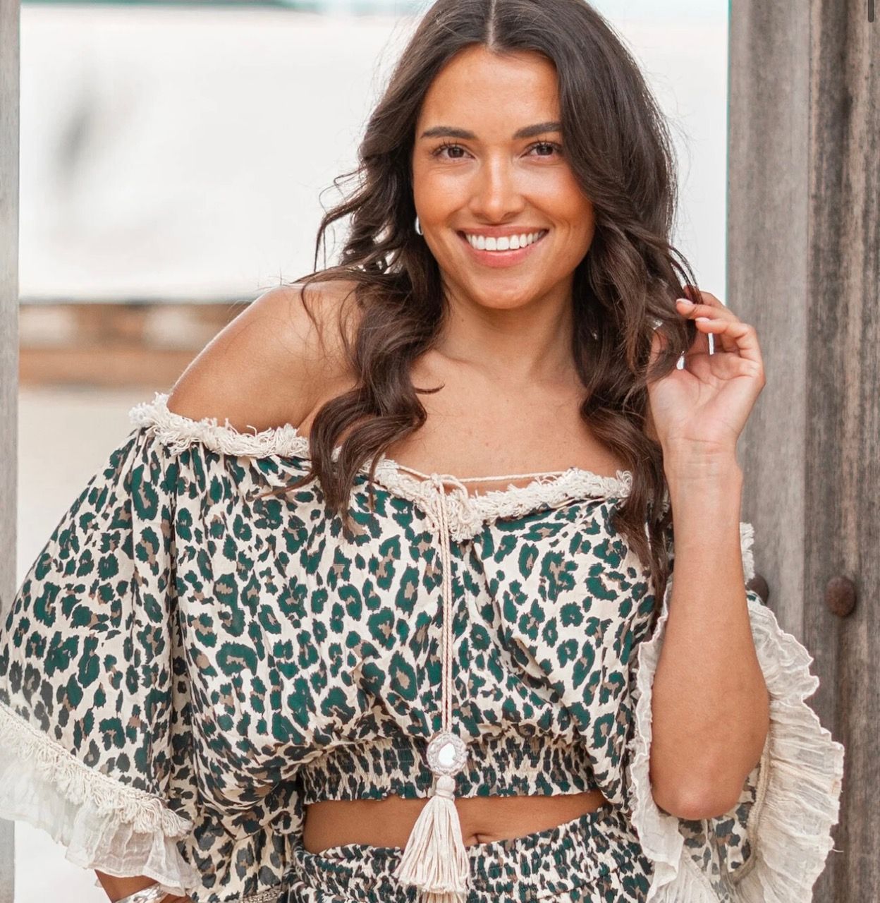A woman wearing a leopard print off the shoulder top