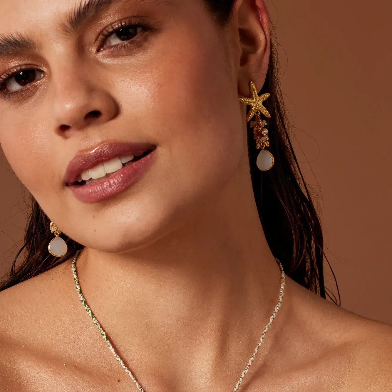 A close up of a woman wearing a necklace and earrings