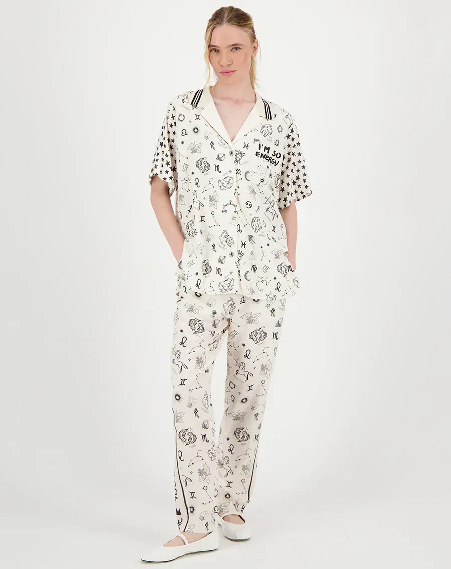 A woman is wearing a white jumpsuit and white shoes